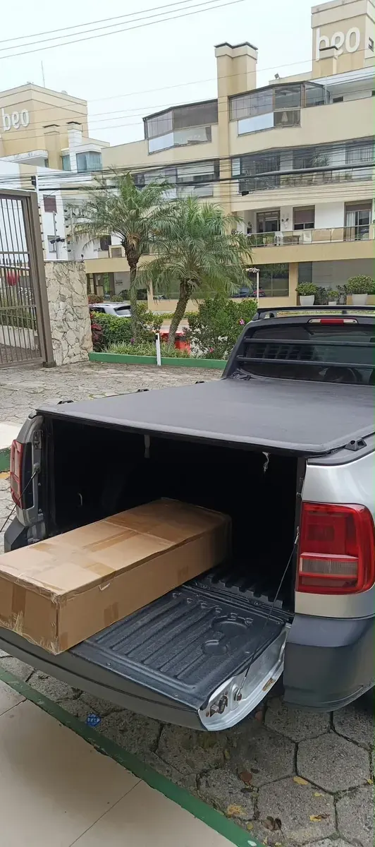 Caixa grande sendo descarregada do utilitário em um condomínio